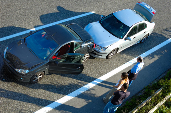 L'immagine mostra un tamponamento tra due veicoli e tre persone a bordo strada